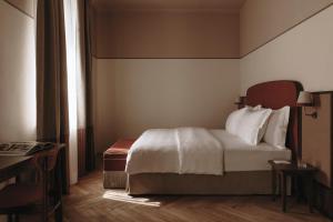 a hotel room with a bed and a window at Parkhotel Mondschein, a Member of Design Hotels in Bolzano