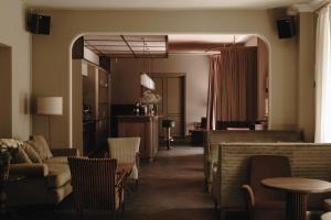 a living room with a couch and a table and chairs at Parkhotel Mondschein, a Member of Design Hotels in Bolzano