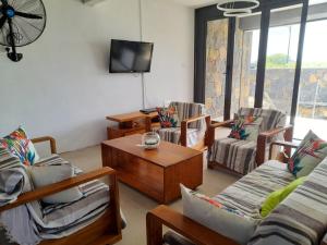 a living room with chairs and a tv and a table at 4 bedrooms house with furnished terrace and wifi at Trou d'Eau Douce 1 km away from the beach in Trou d'Eau Douce