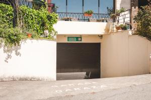 a garage door with a sign on the side of a building at Hotel & Apartments HEC Residence in Sveti Stefan