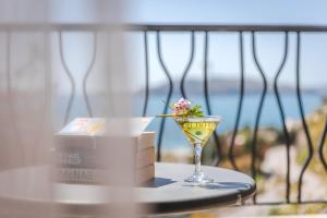 a table with a glass of wine and a box at Hotel & Apartments HEC Residence in Sveti Stefan