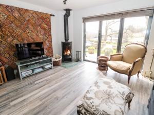 a living room with a fireplace and a tv at Romsey Lodge in Hexham