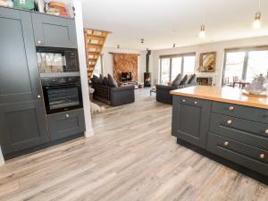 a kitchen with black cabinets and a wooden floor at Romsey Lodge in Hexham