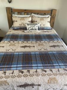 a bed with a quilt on top of it at South Platte Cabins & Kennels in Ogallala