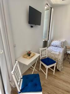玛格丽塔萨沃亚Giglio di Mare rooms的有两把椅子、一张桌子和一台电视的房间