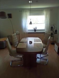 een woonkamer met een tafel en stoelen en een raam bij Ferienwohnung Fritz in Groß Vollstedt