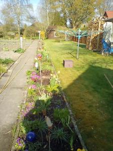 a garden with flowers and a playground at Ferienwohnung Fritz in Groß Vollstedt