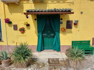 a green door on the side of a yellow building at B&B Comacchio in Comacchio