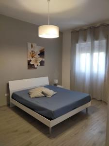 sypialnia z łóżkiem z niebieskim materacem i oknem w obiekcie Casa Punta d'Oro w mieście Faccia di Trippa