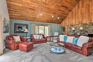 a living room with leather furniture and a stone wall at Decked-Out Home Hot Tub, Pool, Fire Pit and More! in Monroe