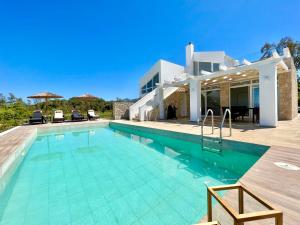 una piscina di fronte a una casa di Luxury Beach Villa DaNune with private pool ad Astrakerí