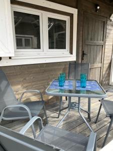 a table and chairs on a porch with blue glasses at Domkoland in Dziwnówek +20 photos
