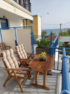 eine Terrasse mit 2 Stühlen und einem Tisch mit Blumen darauf in der Unterkunft Lovely Rooms Finikounda in Finikounda
