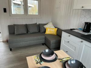 a living room with a couch and a table at Domkoland in Dziwnówek