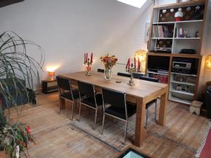 uma sala de jantar com uma mesa de madeira e cadeiras em Artistic loft apartment with big sun terrace em Gent