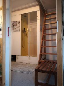a bathroom with a shower and a wooden staircase at Artistic loft apartment with big sun terrace in Ghent