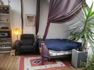um quarto com uma cama, uma cadeira e uma planta em Artistic loft apartment with big sun terrace em Gent