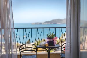 a table with a plant and books on a balcony at Hotel & Apartments HEC Residence in Sveti Stefan