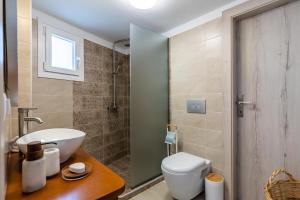 a bathroom with a sink and a toilet at Kyklamino Home - Sea View, Quietly Defined in Skopelos Town +34 photos