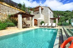 a swimming pool in front of a house at Villa Yaisemi by PosarelliVillas in Kavalléraina