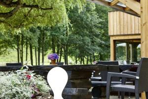 een patio met stoelen, een tafel en bomen bij Hostellerie Les Bagenelles in Sainte-Marie-aux-Mines