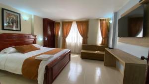 1 dormitorio con 1 cama grande y baño en Hotel Caluva, en Loja