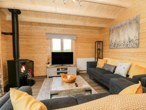 ein Wohnzimmer mit einem Sofa und einem Kamin in der Unterkunft Howgills Retreat in Kendal