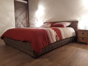sypialnia z łóżkiem z czerwonym i białym kocem w obiekcie Chambres d'hôte des 3 Marches w mieście Lamoura