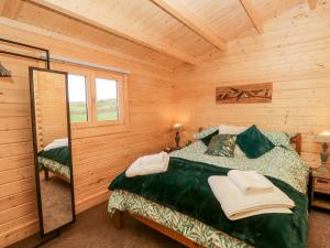 a bedroom with a bed in a wooden cabin at Howgills Retreat in Kendal