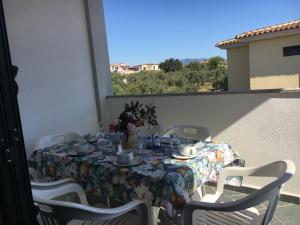una mesa con un mantel floral en el balcón en Sa Domo de Mannoi, en Orosei