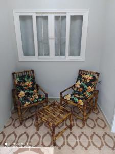 2 Stühle und ein Couchtisch in einem Zimmer in der Unterkunft CASA DU VÔ - Cantinho Du Vô in Santa Teresa
