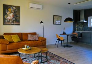 uma sala de estar com um sofá e uma mesa em Erf Hesse - holiday home em Ommen