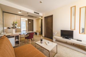 a living room with a couch and a tv at Hotel & Apartments HEC Residence in Sveti Stefan