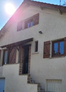 a house with wooden doors on the side of it at Maison de Charme, proche Paris, Maison Laffitte, gare Sartrouville in Sartrouville