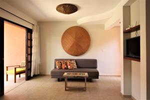 a living room with a couch and a table at Chalé Tulipa - Centro Praia da Pipa in Pipa