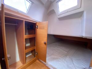 um pequeno quarto com duas janelas e um armário em TROIA - Veleiro em marina em Tróia