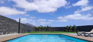 una piscina con una silla y un campo de golf en Villa Geneva - Relax y diversión, en Playa Blanca