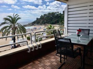 d'un balcon avec une table, des chaises et une plage. dans l'établissement Vivalidays Rosalia - LLoret de Mar centro, à Lloret de Mar