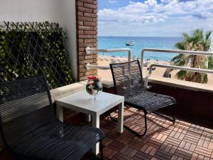 - deux chaises et une table sur un balcon avec vue sur la plage dans l'établissement Vivalidays Rosalia - LLoret de Mar centro, à Lloret de Mar