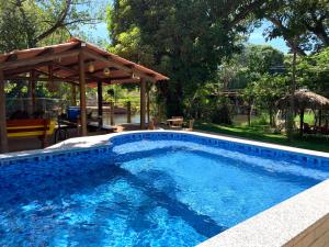 a swimming pool with a gazebo in a yard at Suíte Rio de Ondas 1 in Barreiras