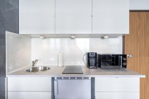 - un comptoir de cuisine avec évier et four micro-ondes dans l'établissement GelsenDesign II - Gemütliches Premium Apartment, à Gelsenkirchen