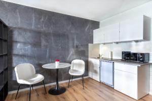 uma pequena cozinha com uma mesa e duas cadeiras em GelsenDesign II - Gemütliches Premium Apartment em Gelsenkirchen