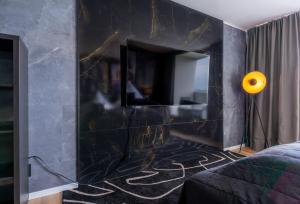 uma sala de estar com uma parede de mármore preto com um espelho em GelsenDesign II - Gemütliches Premium Apartment em Gelsenkirchen