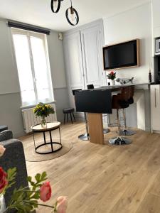 een woonkamer met een piano en een televisie bij L'évasion in Honfleur