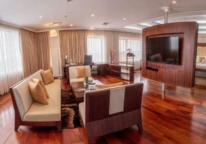 ein Wohnzimmer mit einem Sofa und einem TV in der Unterkunft Hillary Nature Resort & Spa All Inclusive in Arenillas