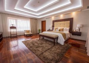 una grande camera da letto con un grande letto e un tappeto di Hillary Nature Resort & Spa All Inclusive ad Arenillas
