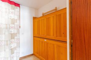 Cette chambre comprend un placard avec une porte en bois. dans l'établissement Apartment with Balcony and View, au Grand-Bornand