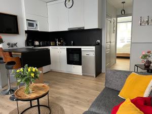 een woonkamer met een bank en een keuken bij L'évasion in Honfleur