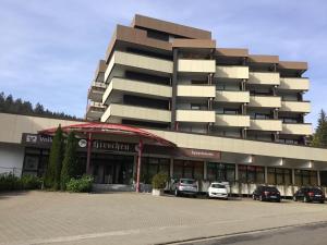 a large building with cars parked in a parking lot at 1Z.FeWo 236 barbo Schwimmbad,Sauna,Fitness in Schönwald