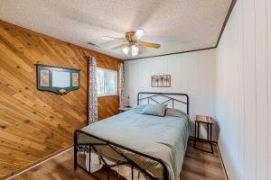 een slaapkamer met een bed en een plafondventilator bij Rustic Cabin in Bass Lake